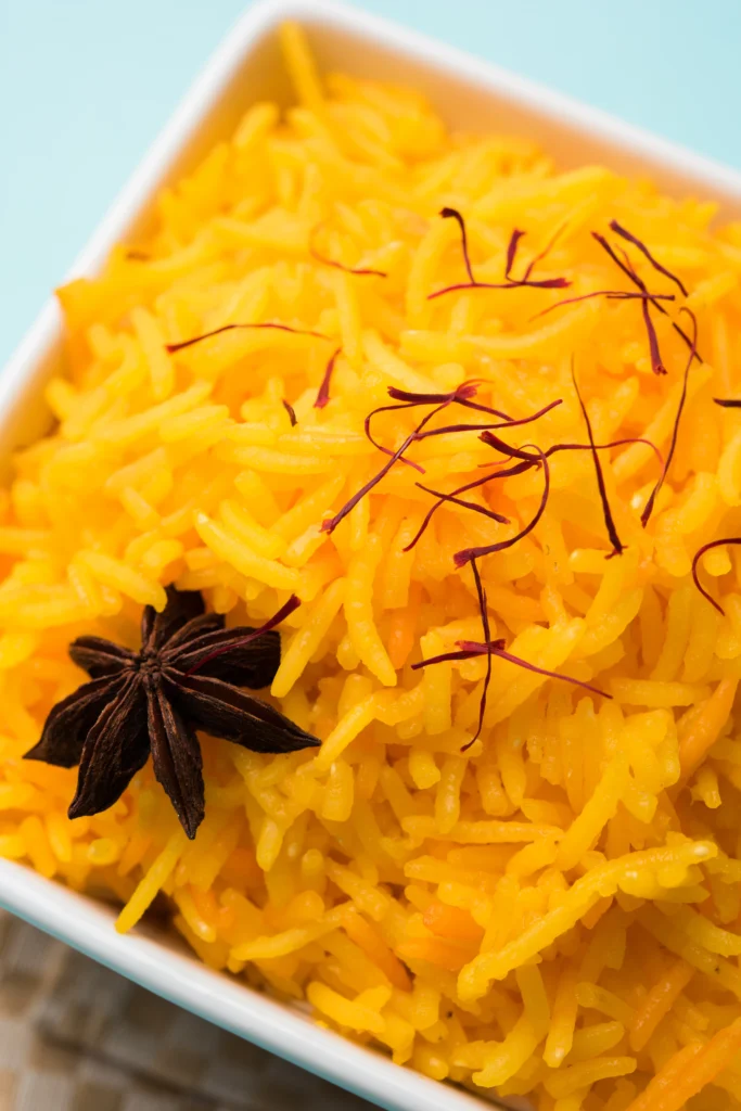 Authentic Persian saffron rice with golden tahdig and barberry garnish served on a traditional platter