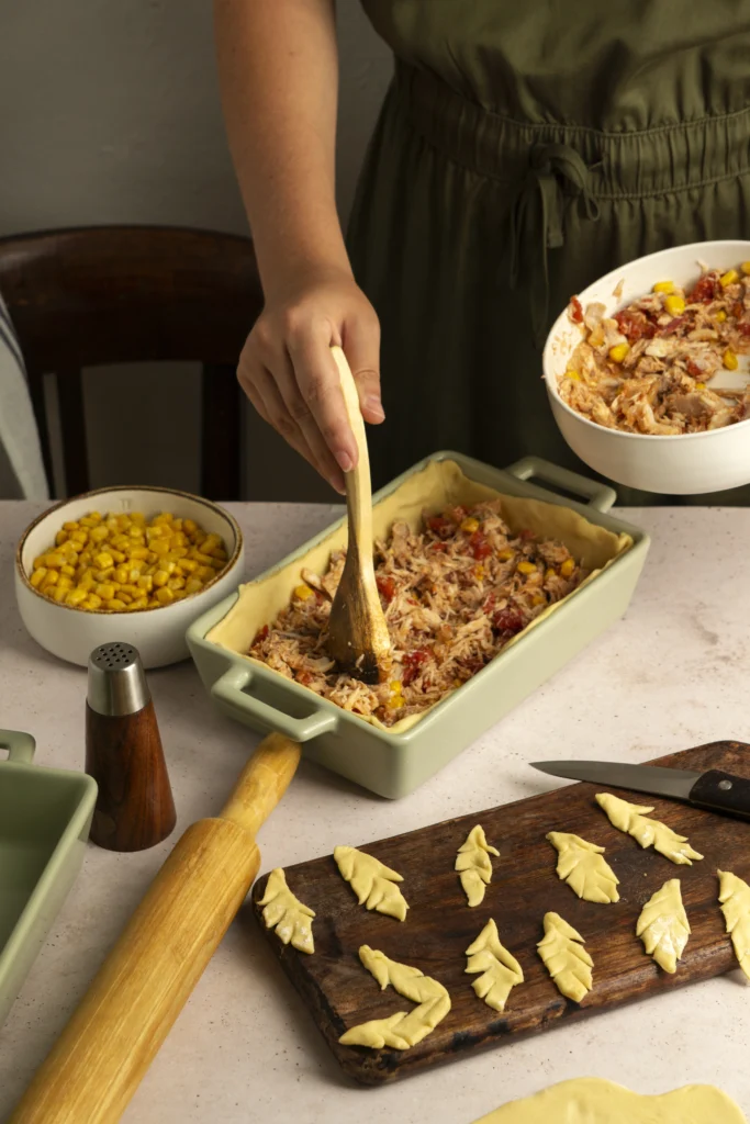 Delicious Taco Lasagna with layers of seasoned beef, melted cheese, and crispy tortillas, topped with fresh cilantro and a dollop of sour cream