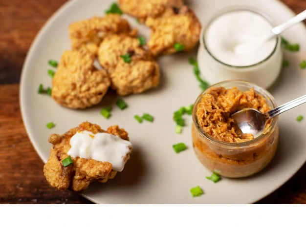 Homemade Chick-fil-A grilled nuggets served with dipping sauce and vegetables on a white plate