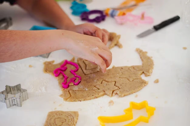 Colorful homemade playdough balls made without cream of tartar, with children's hands playing in the background.