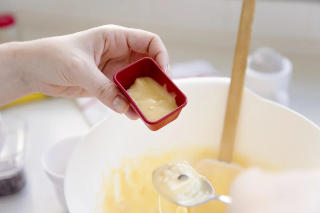 Close-up of a layered Buttery Nipple shot with smooth Baileys and golden butterscotch schnapps in a clear shot glass