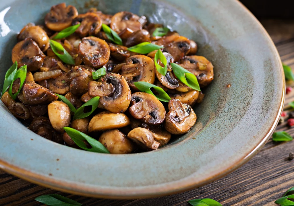 A close-up of a delicious vegan mushroom stroganoff served over pasta, garnished with fresh parsley.