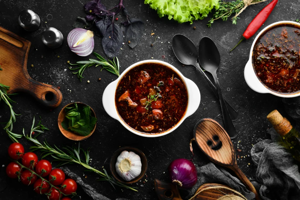 Bowl of authentic elk chili topped with fresh herbs and served with cornbread on the side