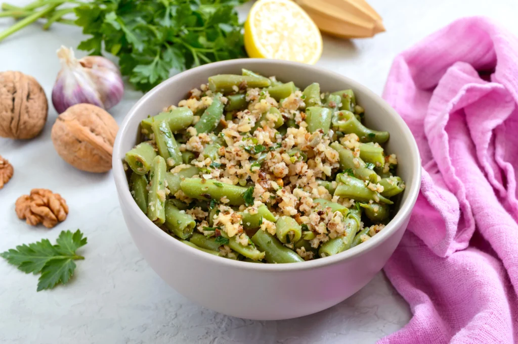 A delicious bowl of seasoned bush beans cooked with herbs and spices, garnished with fresh parsley.