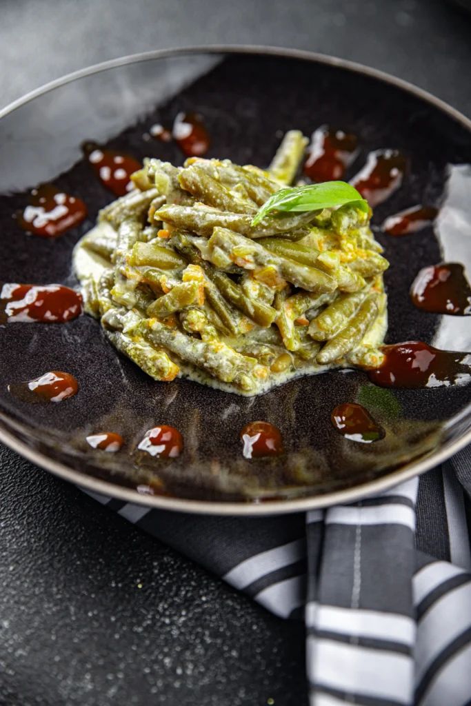 A delicious bowl of seasoned bush beans cooked with herbs and spices, garnished with fresh parsley.