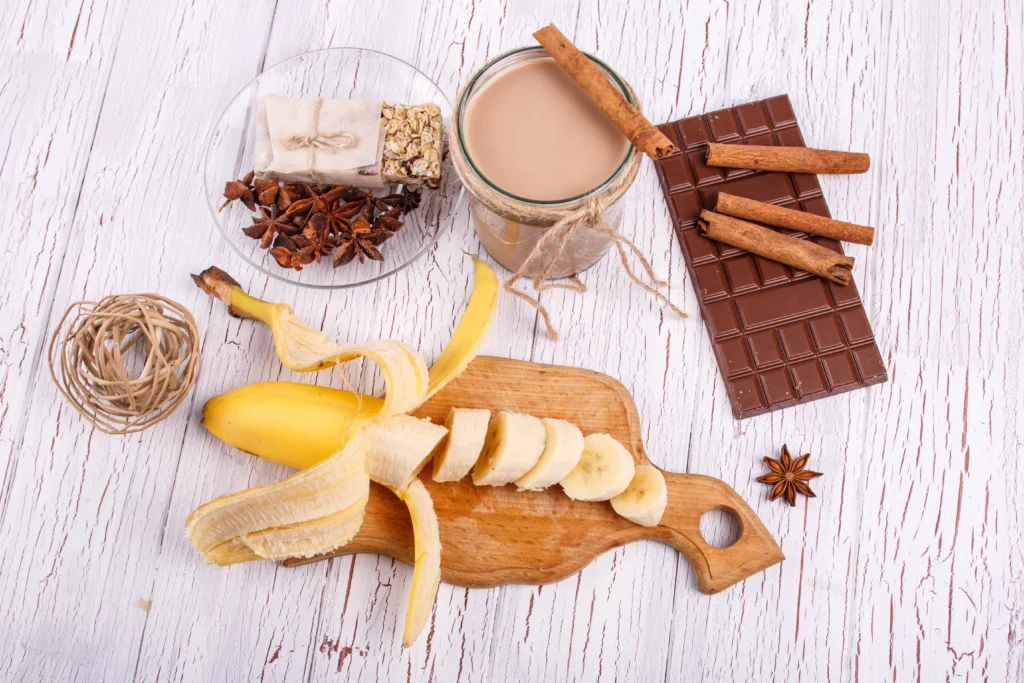 Iced banana coffee drink in a tall glass with a straw and banana slices garnish