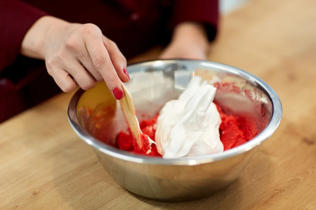 Homemade strawberries and cream ice cream in a bowl with fresh strawberries on top