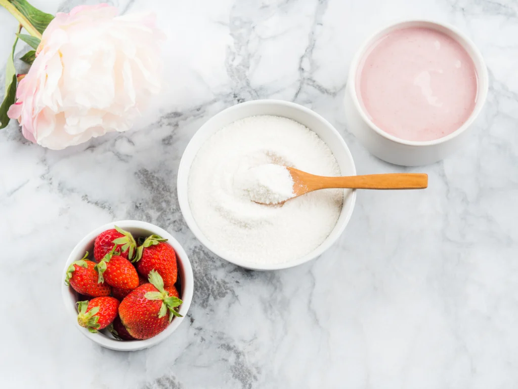 Homemade strawberries and cream ice cream in a bowl with fresh strawberries on top