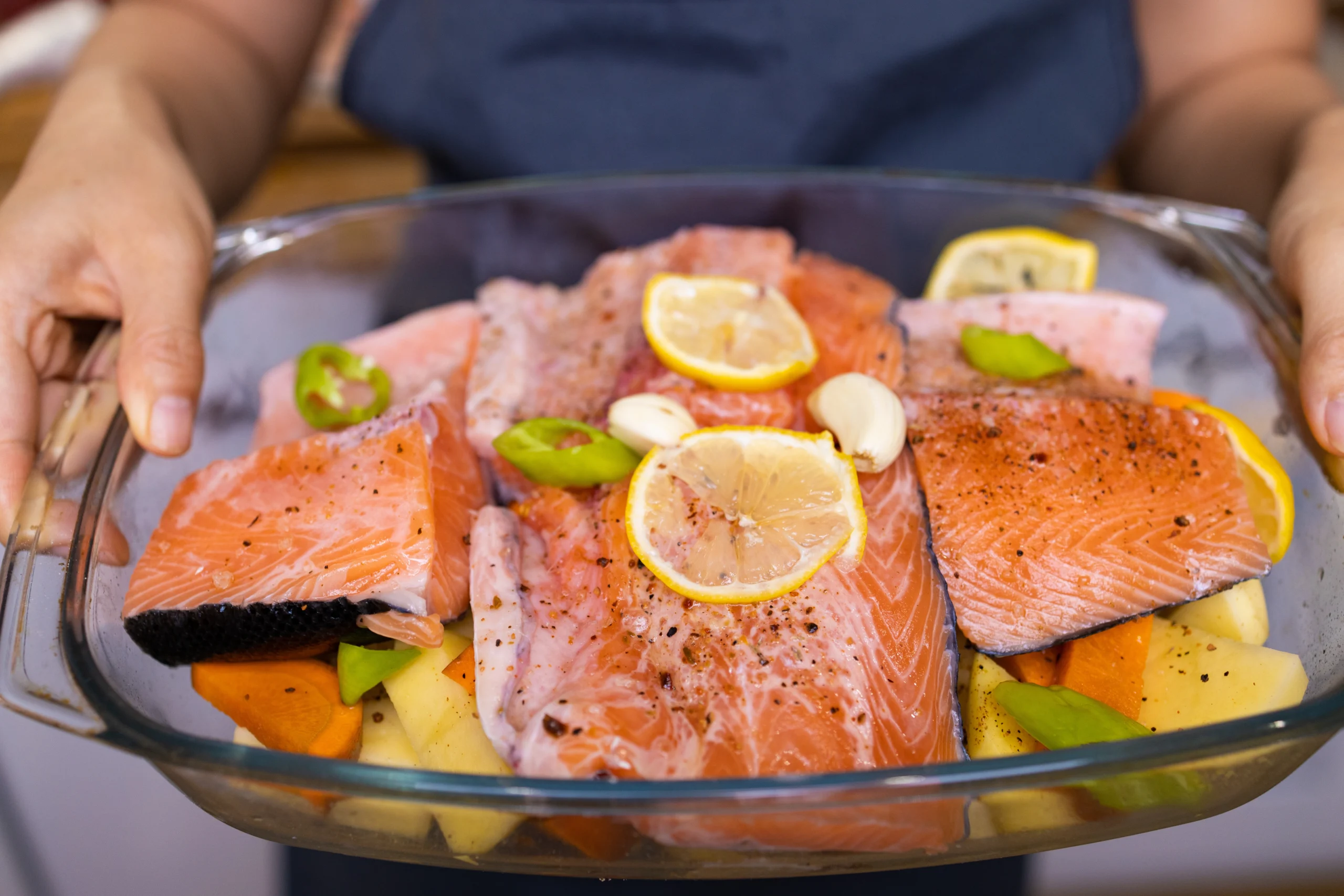 Oven-baked King salmon fillets with lemon, dill, and parsley on a white ceramic plate