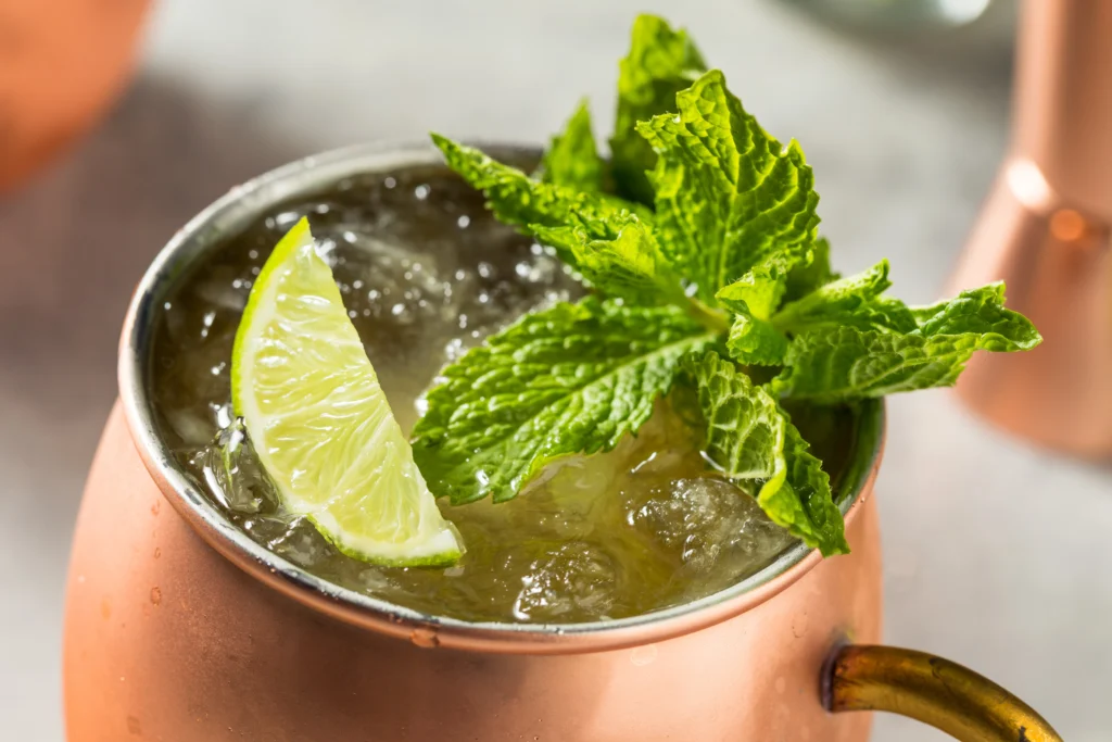 A refreshing Kentucky Mule cocktail served in a classic copper mug with lime wedge and mint garnish