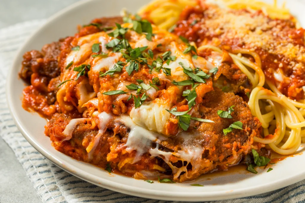 Crispy Air Fryer Chicken Parmesan topped with melted mozzarella and marinara sauce, served with fresh basil garnish
