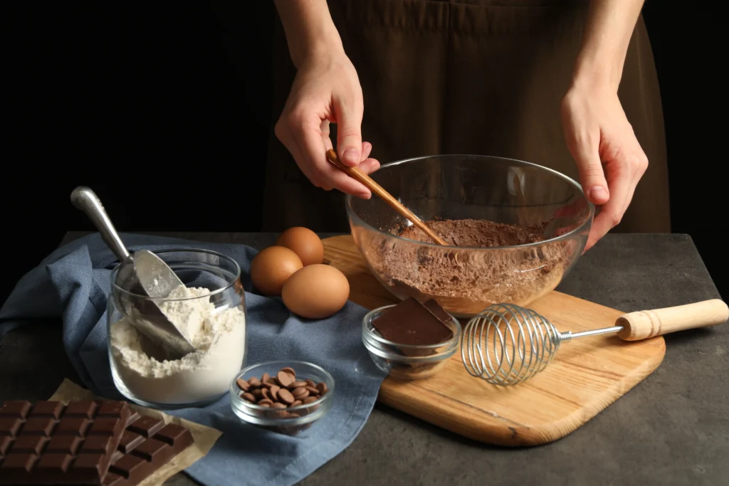 Slice of moist one-bowl chocolate cake with chocolate frosting on a white plate