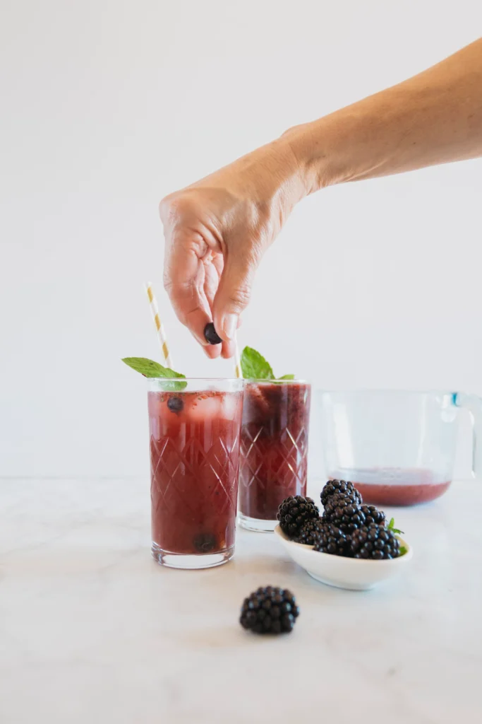 Refreshing Transfusion cocktail with vodka, grape juice, and ginger ale served with ice and lime wedge