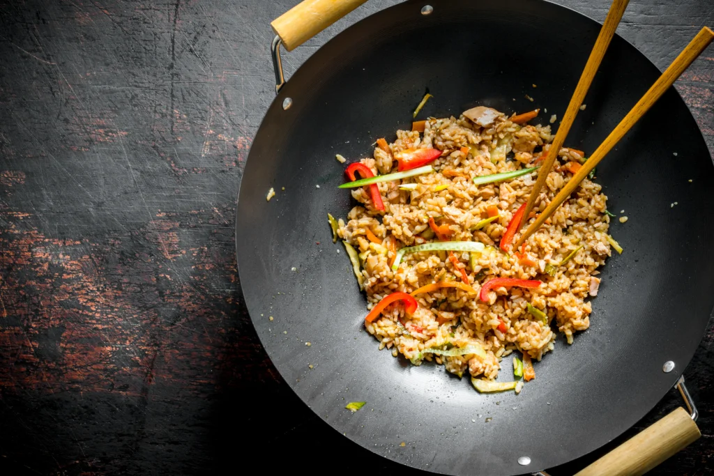 Step-by-step preparation of Blackstone fried rice on a flat top griddle with vegetables, eggs, and rice being stir-fried