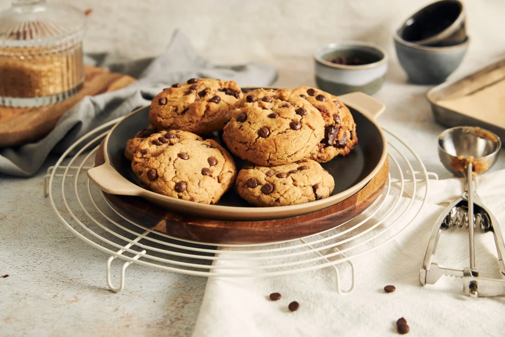 Freshly baked Nestlé Toll House chocolate chip cookies on a cooling rack