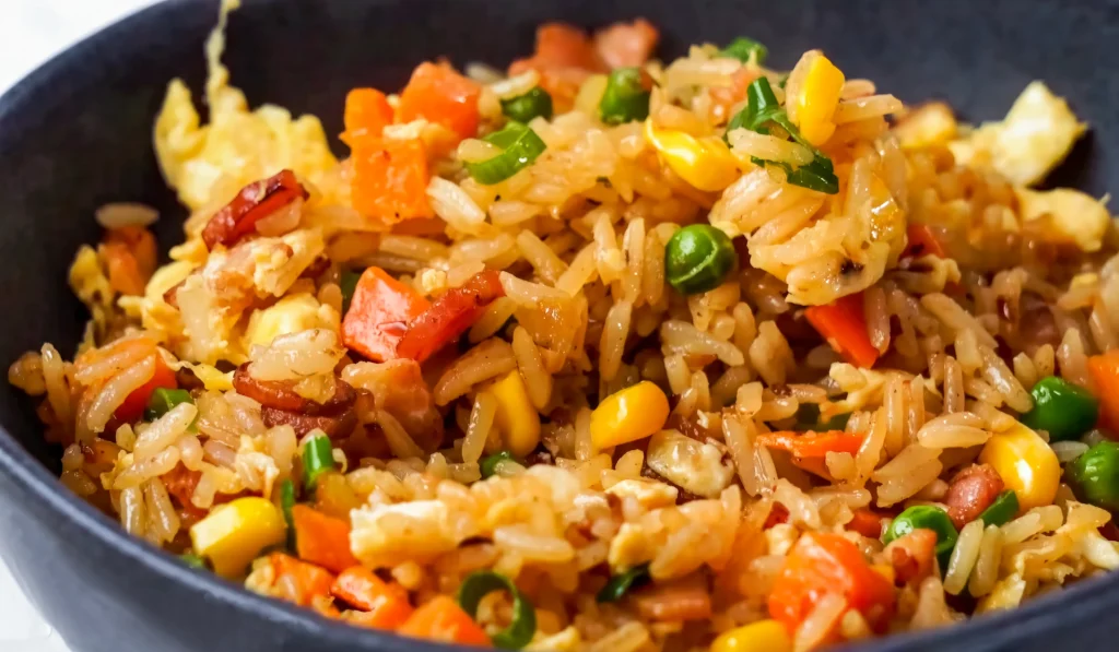 Step-by-step preparation of Blackstone fried rice on a flat top griddle with vegetables, eggs, and rice being stir-fried