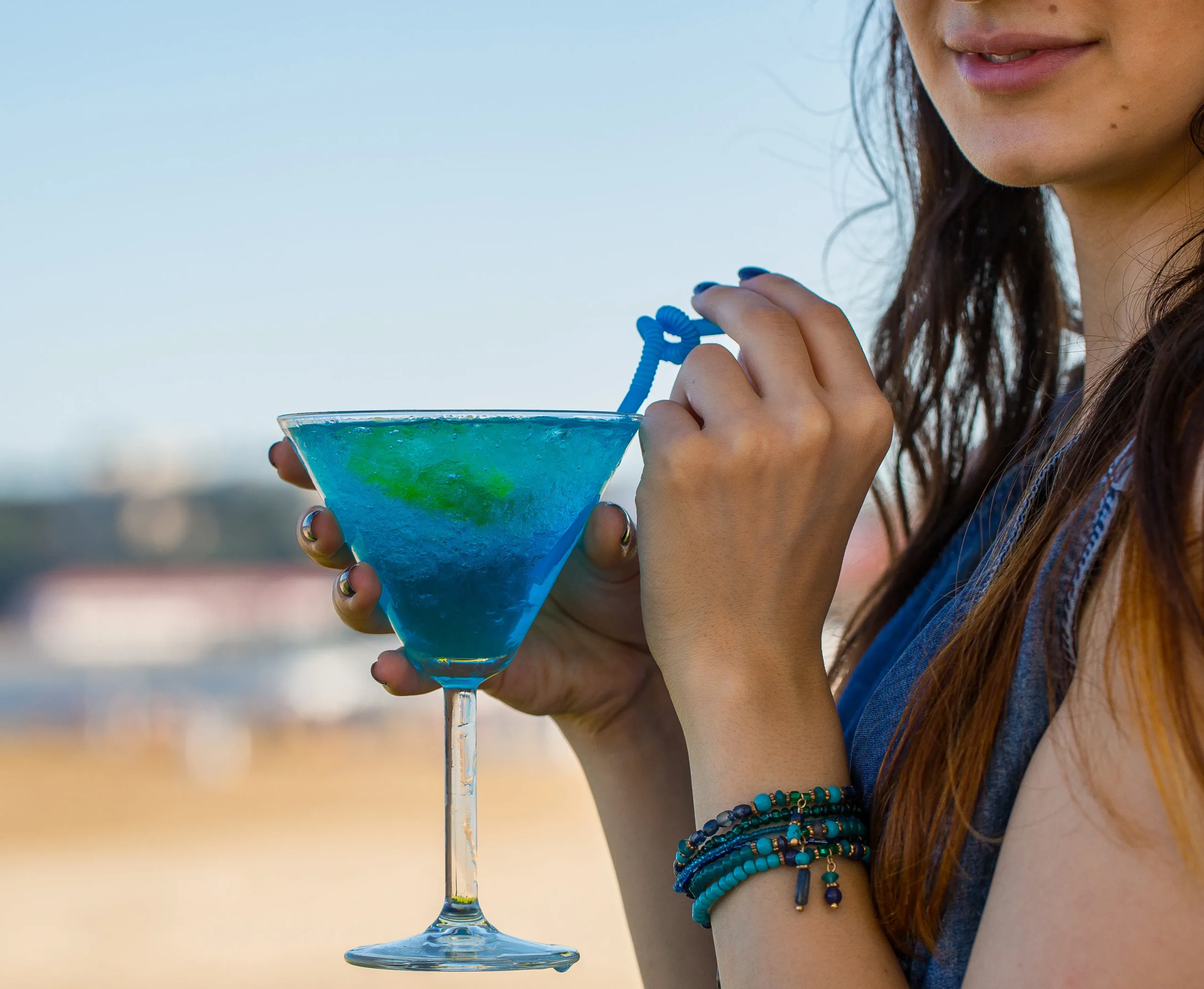 Blue Margarita cocktail in a glass with a lime wedge and blueberries, garnished with a salt rim, served on a summer night