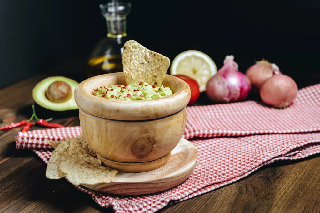 Ultimate Boat Dip served with tortilla chips, garnished with bacon, jalapeños, and green onions.