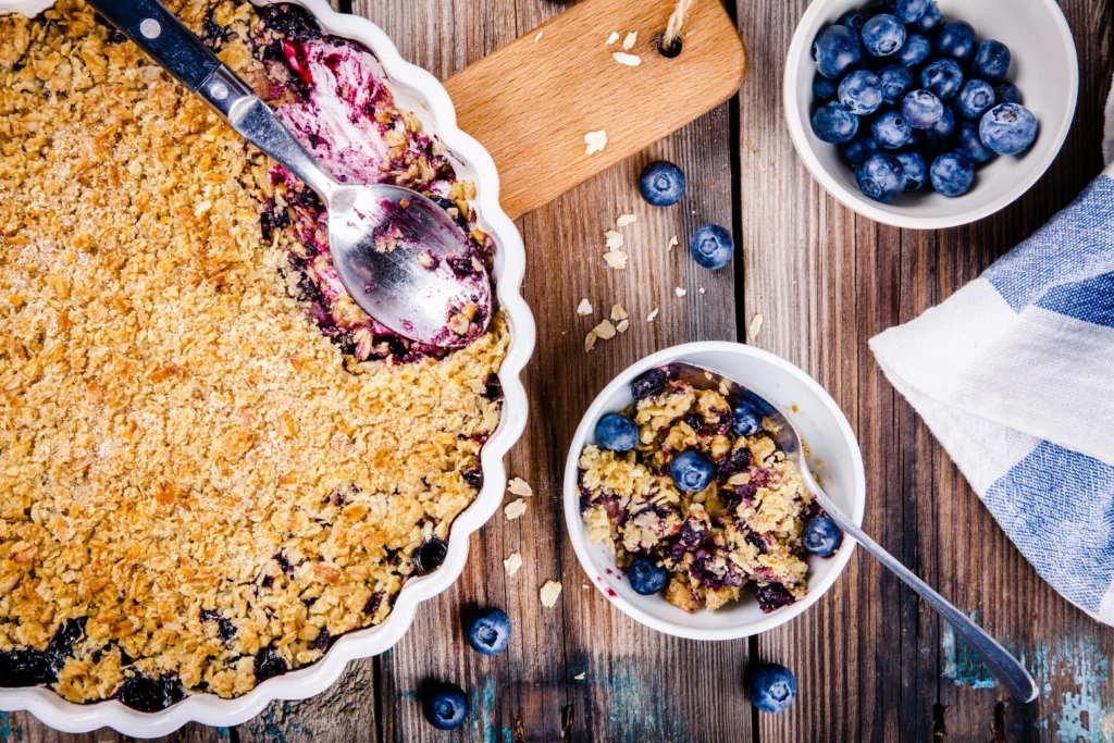 Freshly baked homemade blueberry rustic crumble with oats, served warm in a baking dish