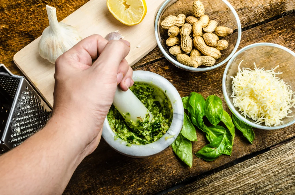 Pesto recipe without pine nuts served with pasta, topped with Parmesan and fresh basil