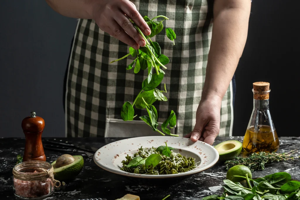 Pesto recipe without pine nuts served with pasta, topped with Parmesan and fresh basil