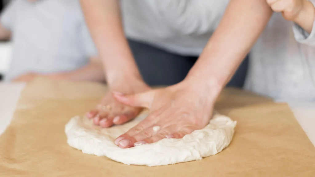 Homemade thin crust pizza dough rolled out on a floured surface, ready for baking.