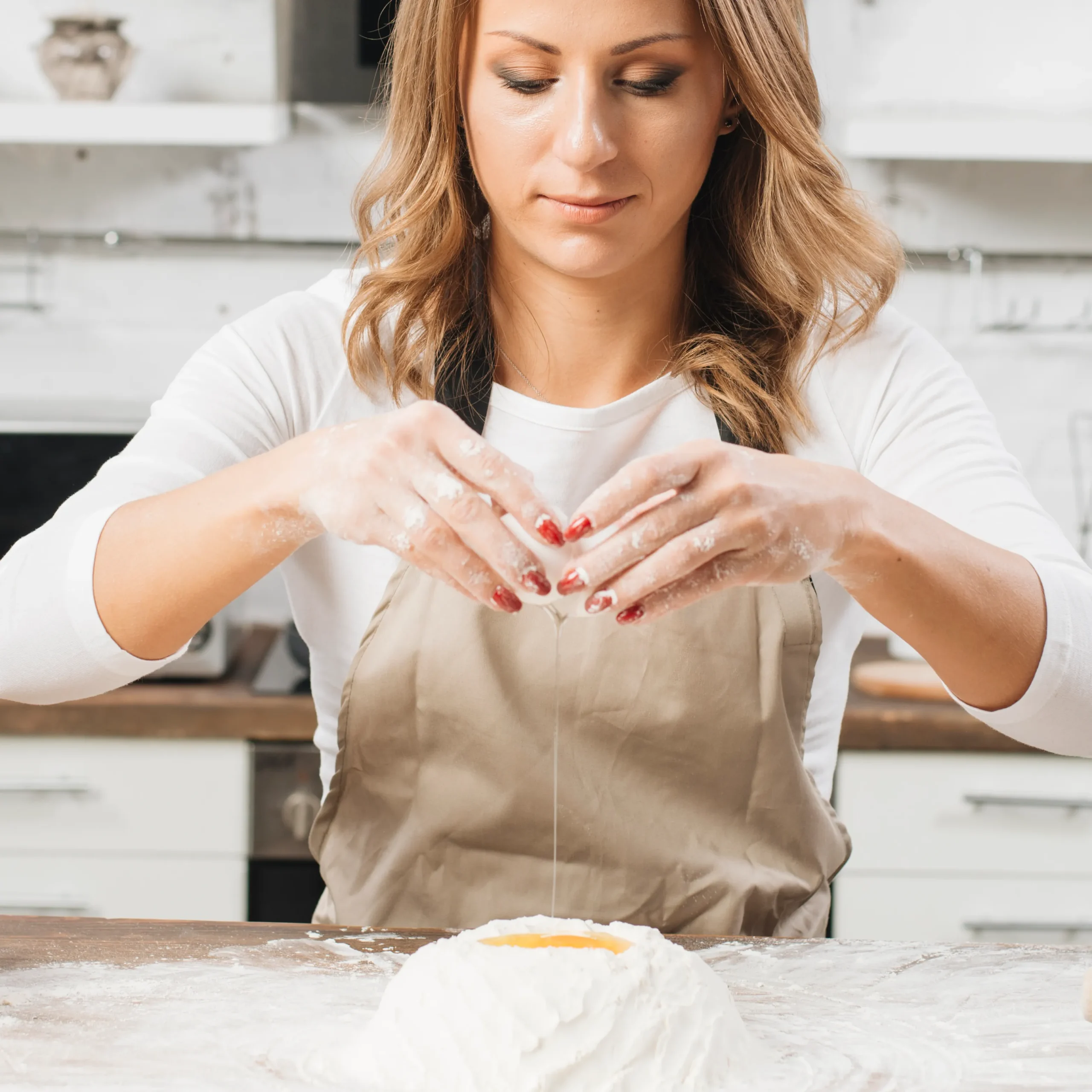 Freshly baked homemade bagels cooling on a wire rack, with cream cheese on the side.