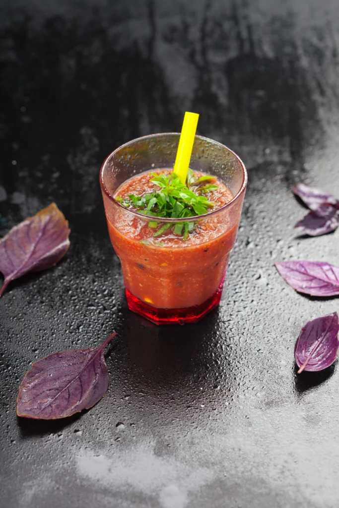 Vegan cocktail sauce in a small bowl with lemon and horseradish, served with vegan shrimp and veggies