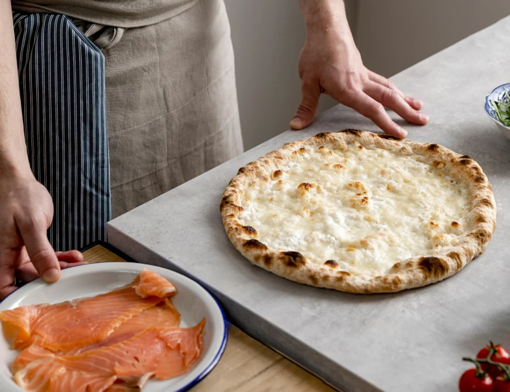 Homemade thin crust pizza dough rolled out on a floured surface, ready for baking.