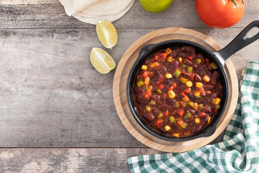 A hearty vegetarian crockpot meal with fresh vegetables, beans, and herbs simmering in a slow cooker.