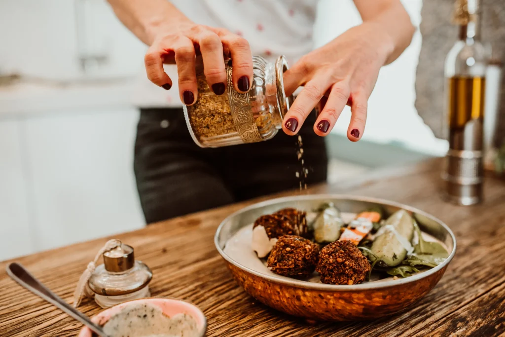 A bowl of homemade smoky chili seasoning blend with paprika, cumin, and chili powder on a rustic wooden table.