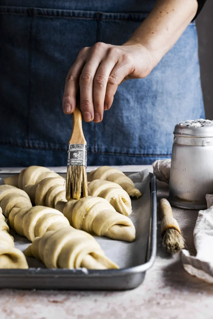 Freshly baked French croissants with golden, flaky layers on a wooden board
