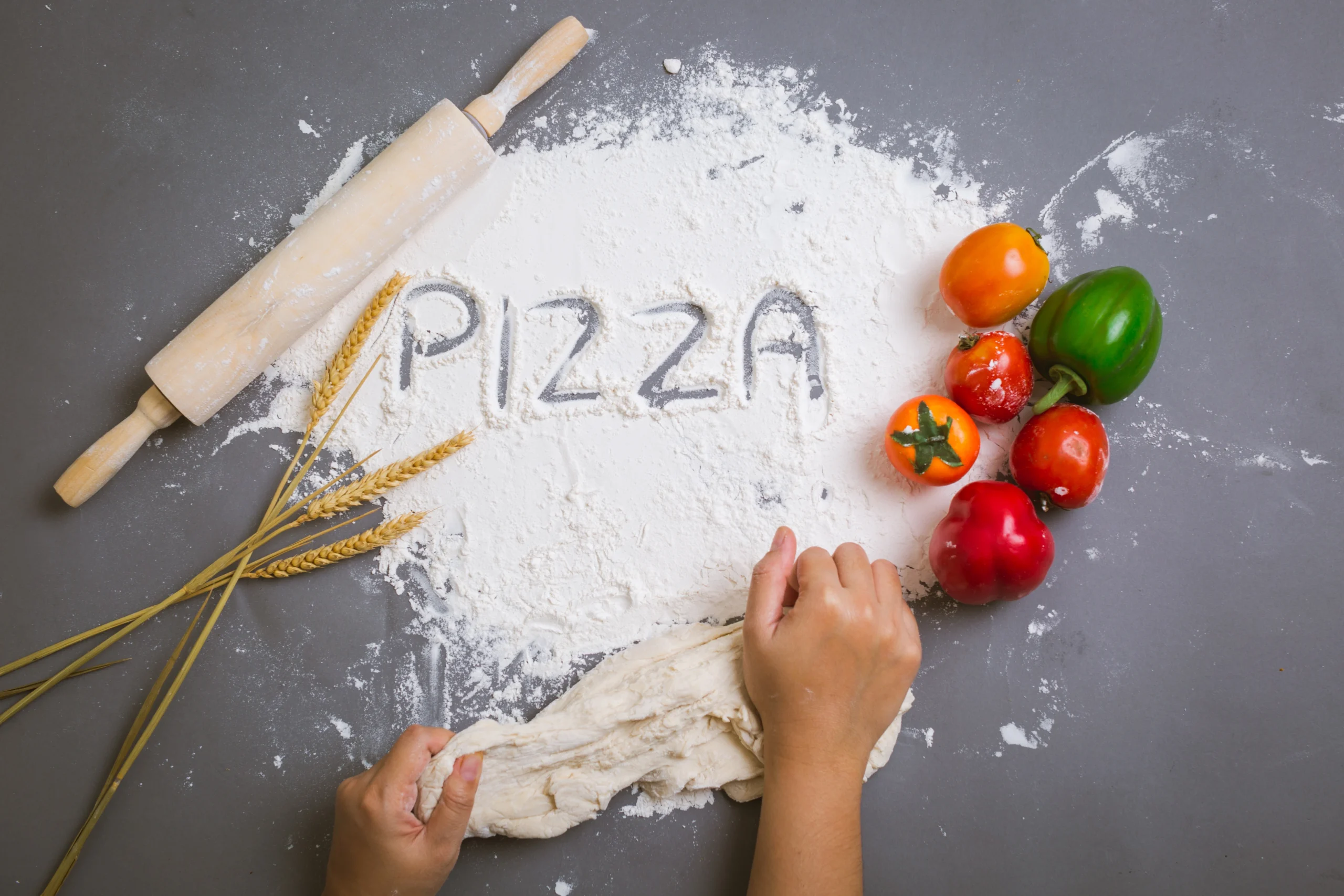 Homemade thin crust pizza dough rolled out on a floured surface, ready for baking.