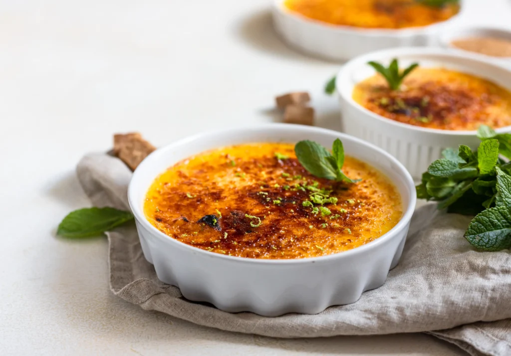 Golden Crab Brulee topped with melted Gruyère cheese and caramelized shallots in a ramekin