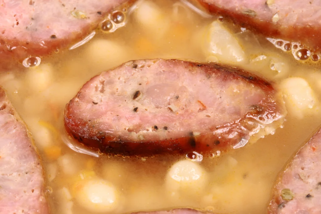 Homemade Ham and Bean Soup with Great Northern Beans in a bowl, garnished with fresh herbs and served with crusty bread