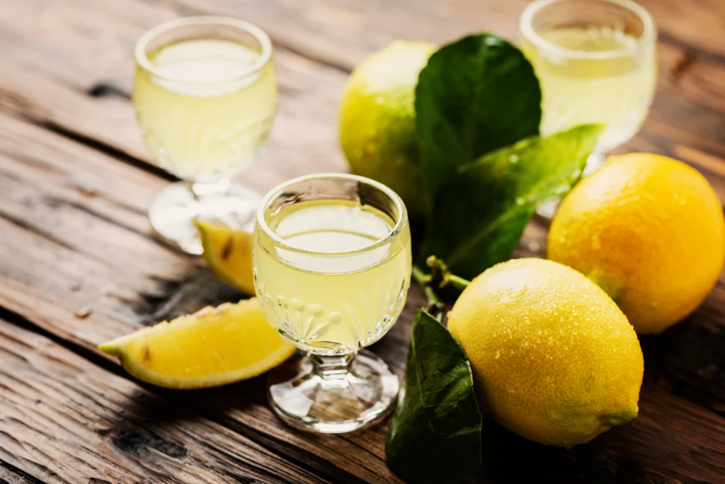 Refreshing homemade limoncello in a glass bottle with fresh lemons