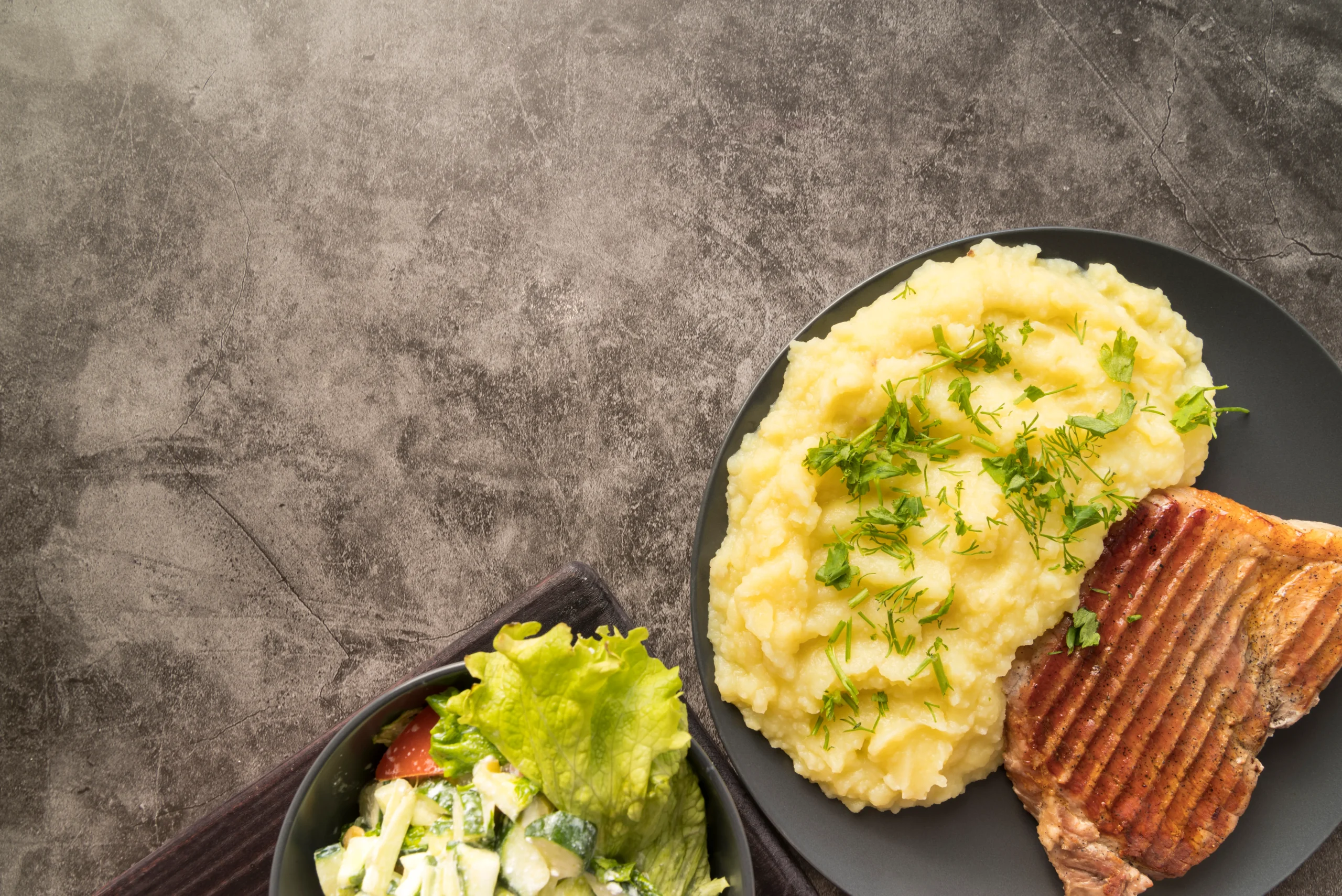 A rustic plate filled with crispy mashed potato cakes, garnished with fresh herbs, served with a small bowl of sour cream on a wooden table, showcasing creative ways to use leftover mashed potatoes.