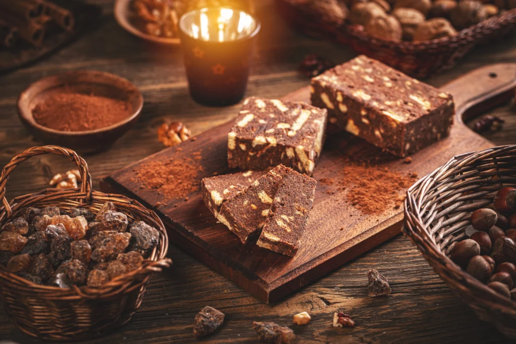 Quick and Magical Fantasy Fudge squares topped with walnuts on a wooden board.