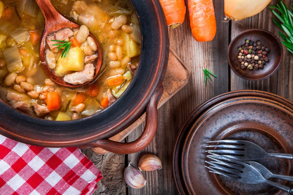 Homemade Ham and Bean Soup with Great Northern Beans in a bowl, garnished with fresh herbs and served with crusty bread
