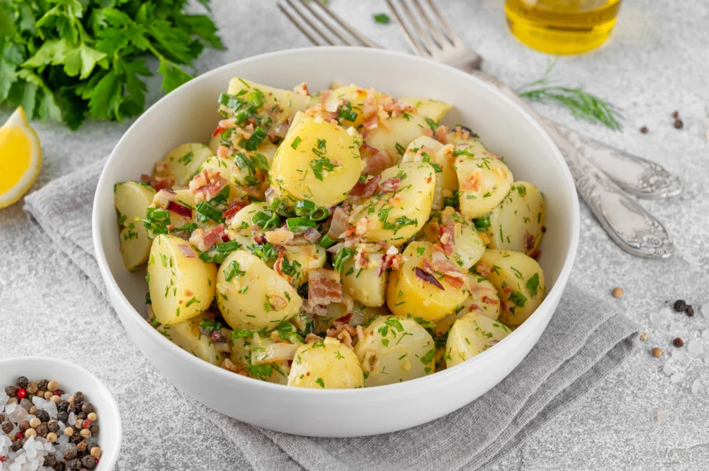 The Best  German potato salad with bacon, onions, and fresh parsley in Grandma’s traditional recipe style