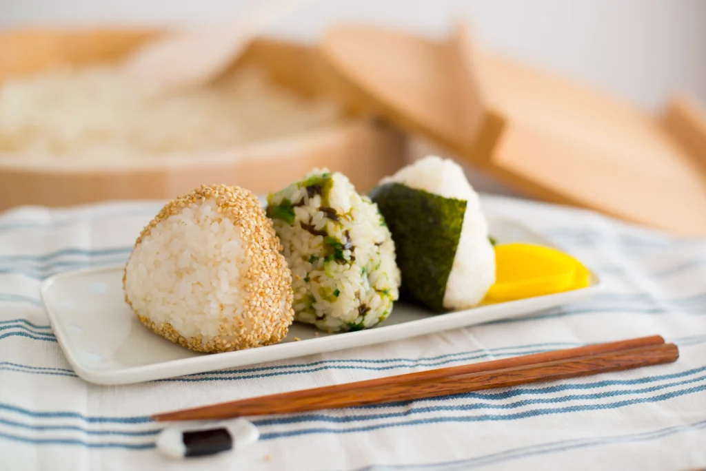 Traditional Japanese onigiri rice balls wrapped in seaweed, ready to eat.