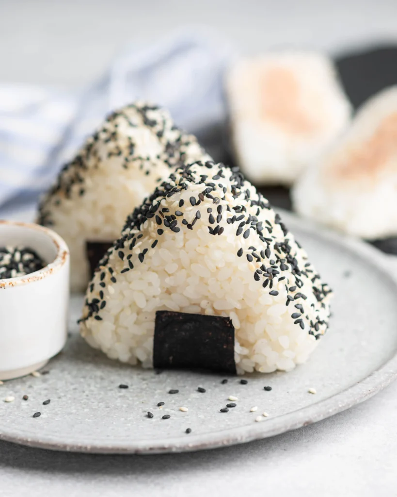 Traditional Japanese onigiri rice balls wrapped in seaweed, ready to eat.