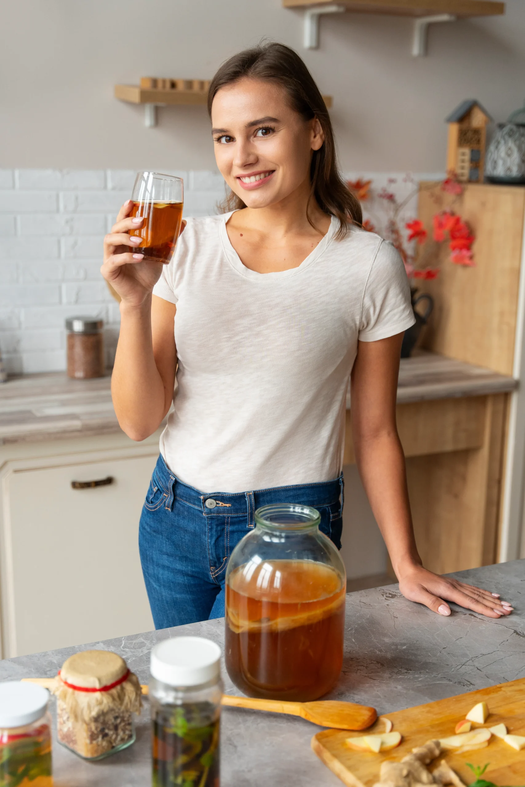 Authentic kombucha brewing at home using four simple ingredients with SCOBY, tea, sugar, and water in a glass jar