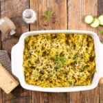 Zucchini noodle pesto bake with melted cheese and fresh basil on top