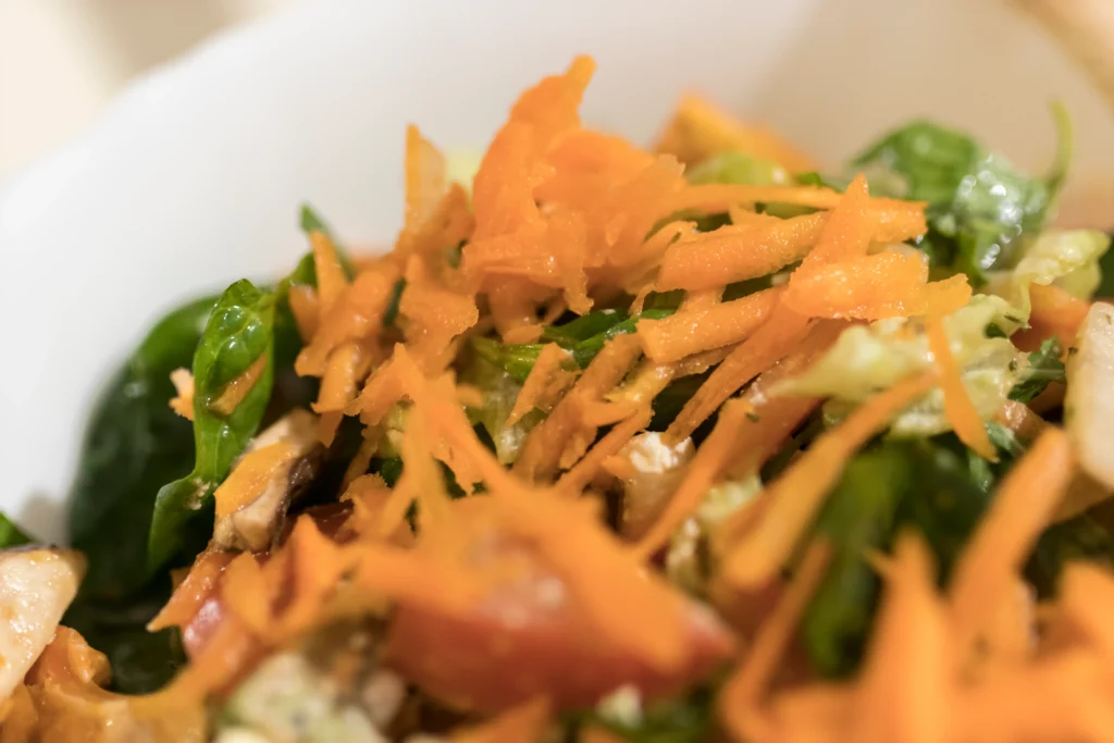 Moroccan Carrot & Orange Salad made with fresh carrots, juicy orange slices, olive oil, and Moroccan spices served in a rustic bowl