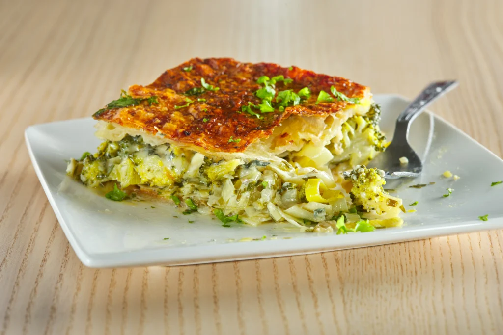 Zucchini noodle pesto bake with melted cheese and fresh basil on top