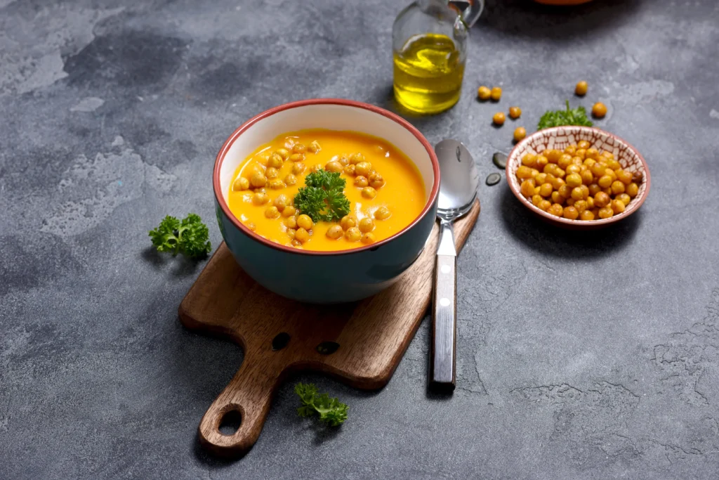 Creamy butternut squash and chickpea soup served in a bowl, garnished with fresh herbs