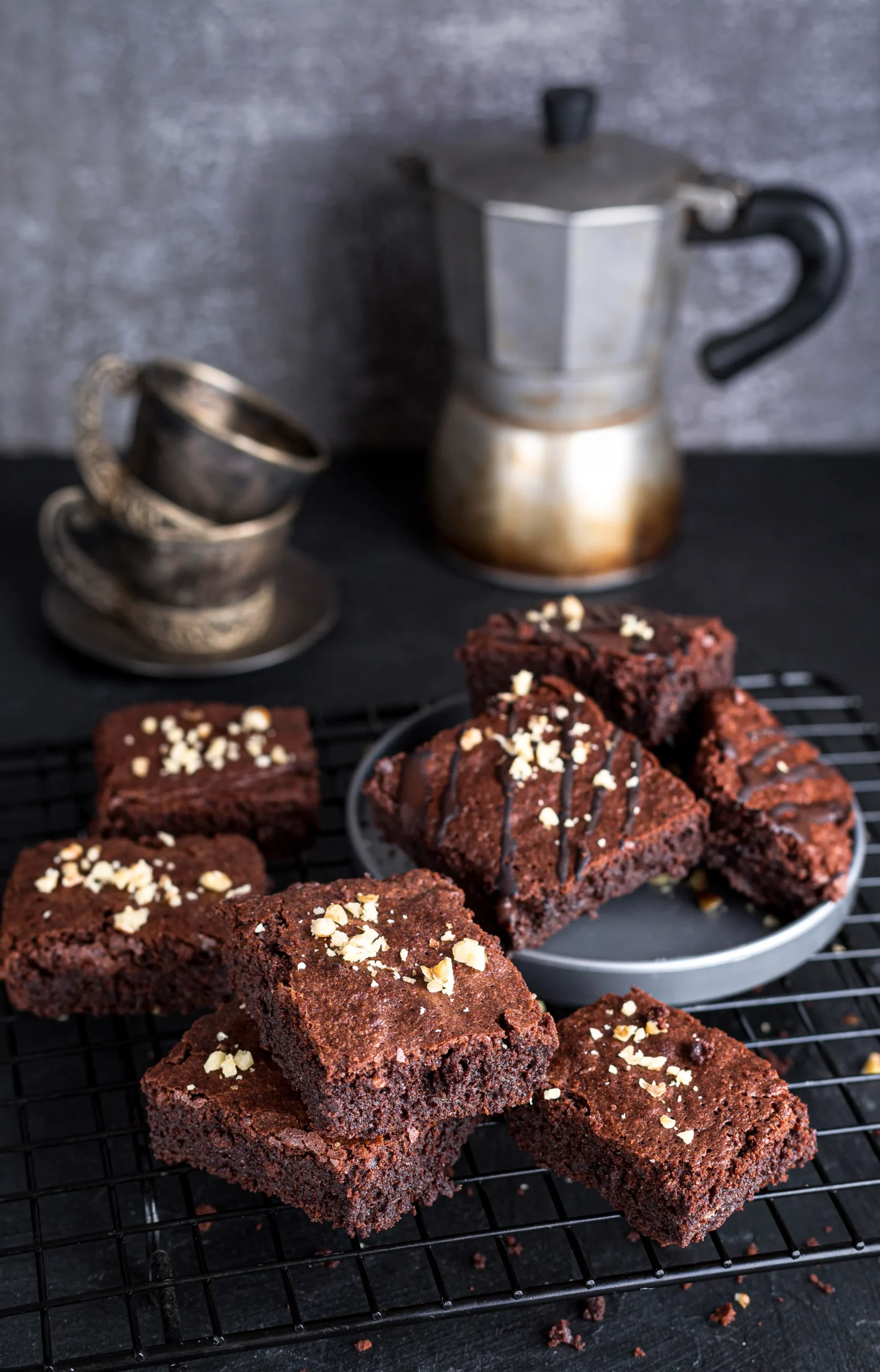 Rich dark chocolate brownies topped with crunchy pecans on a wooden plate