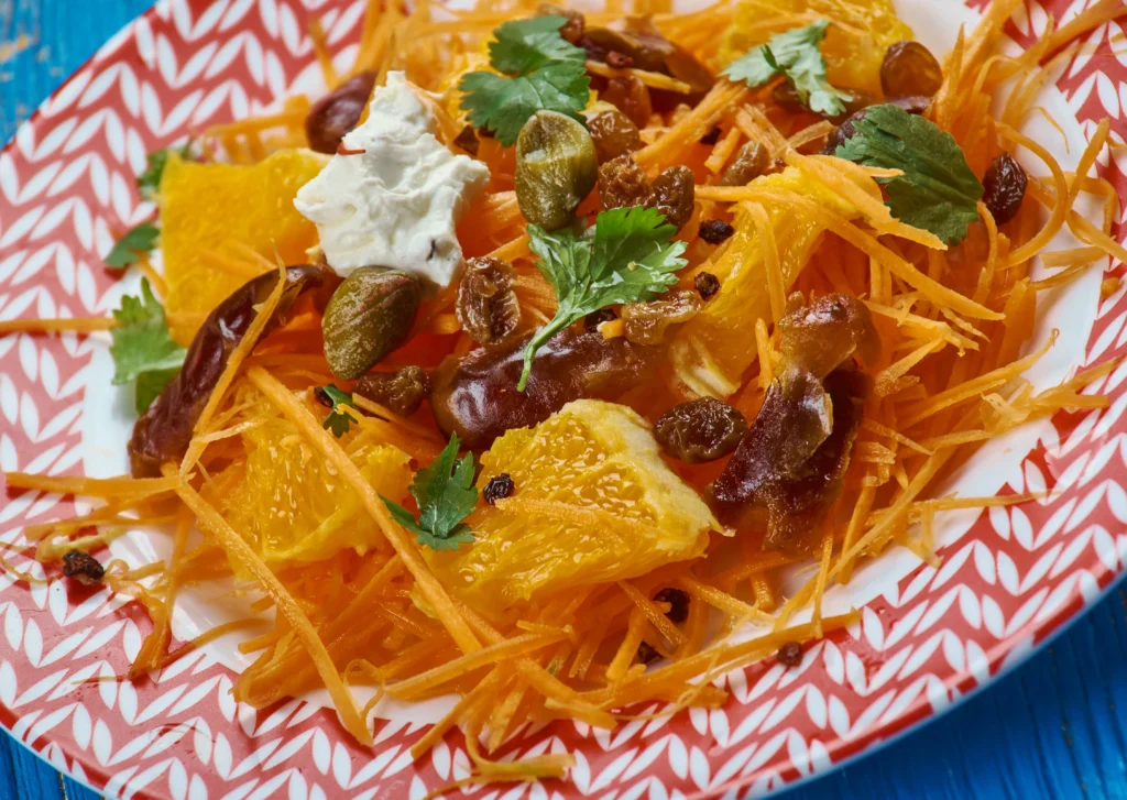 Moroccan Carrot & Orange Salad made with fresh carrots, juicy orange slices, olive oil, and Moroccan spices served in a rustic bowl