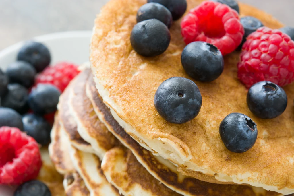 Healthy gluten-free pancakes made with natural ingredients, topped with fresh berries and maple syrup